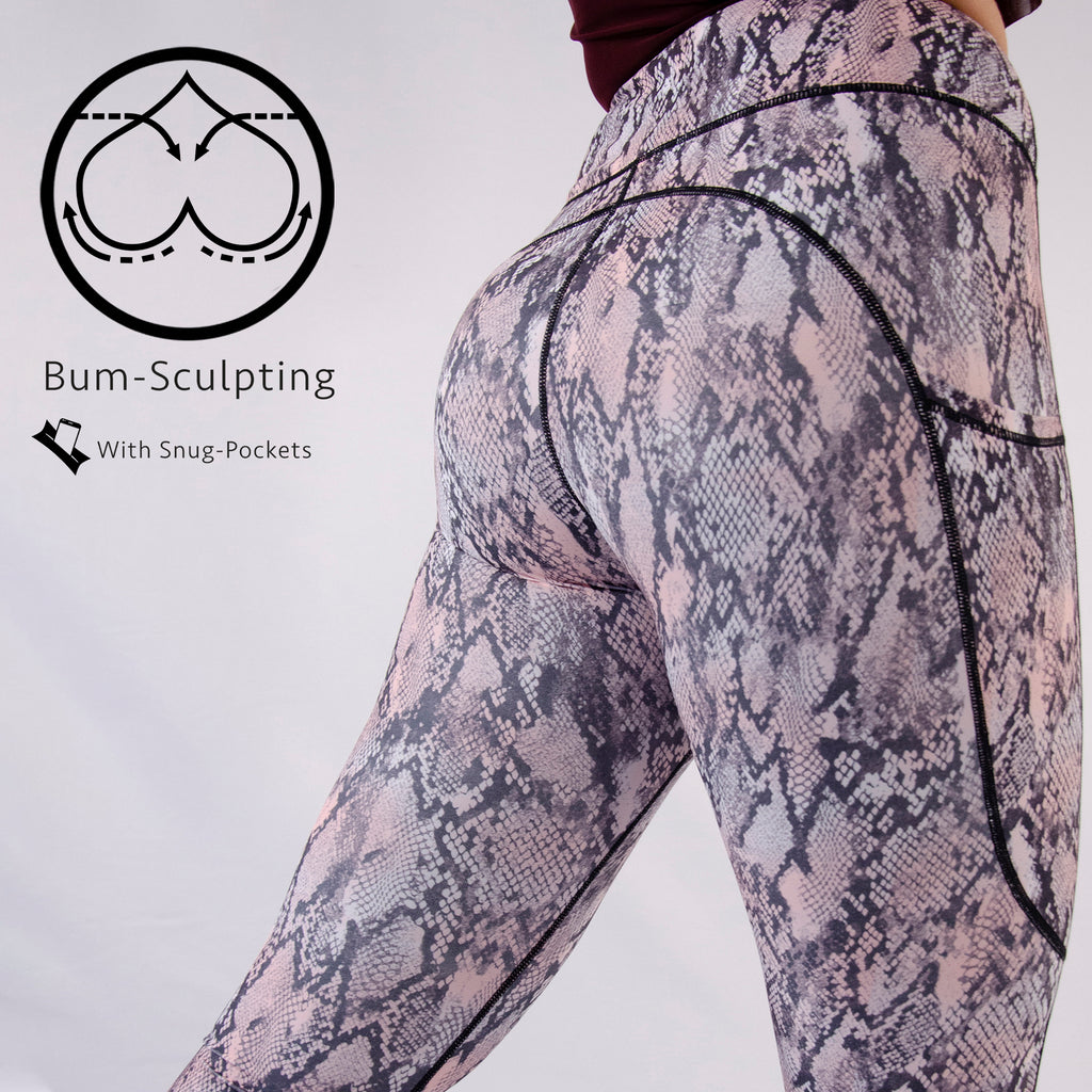 Woman wearing bum sculpting leggings with snake print in light pink colour 