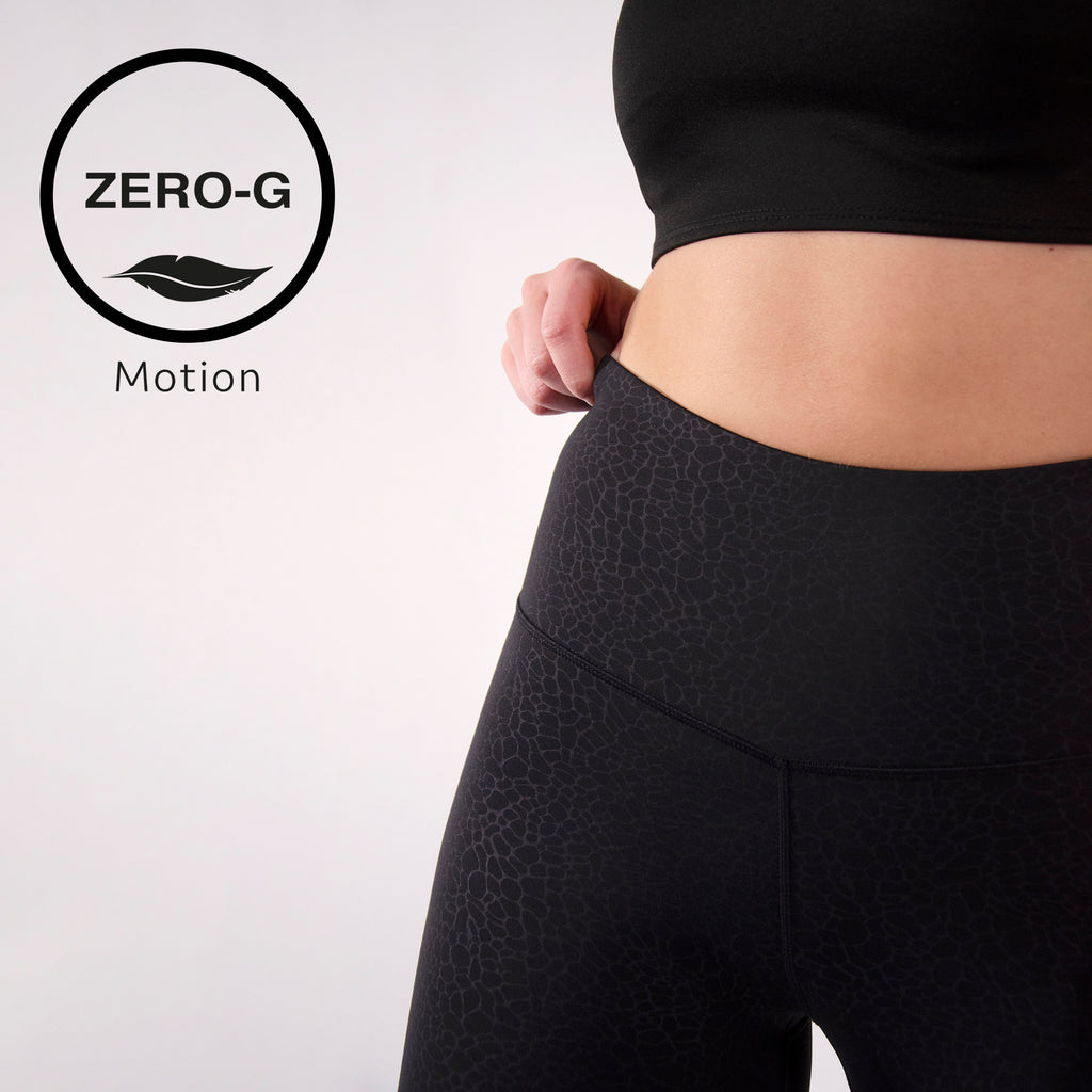 Woman wearing light weight silky gym leggings in textured black 