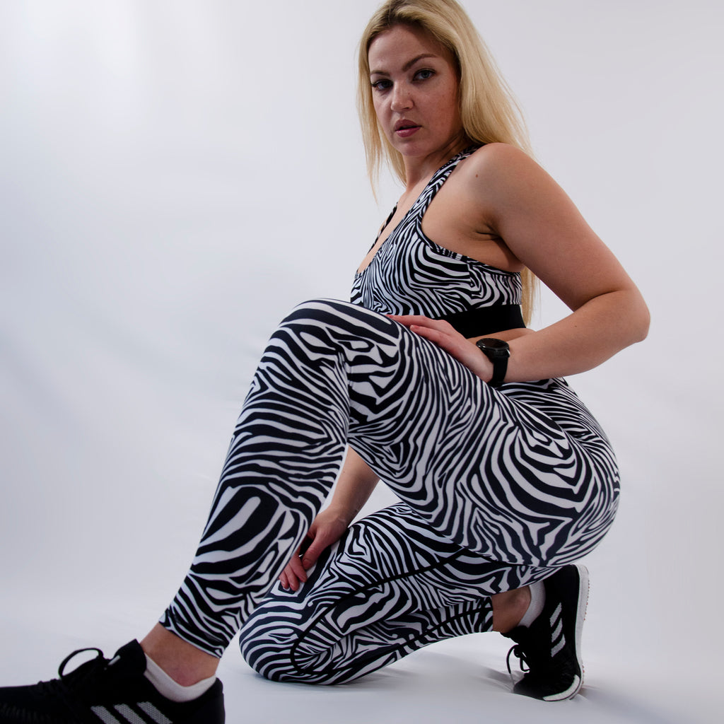 Woman wearing gym patterned leggings with high waist and zebra print